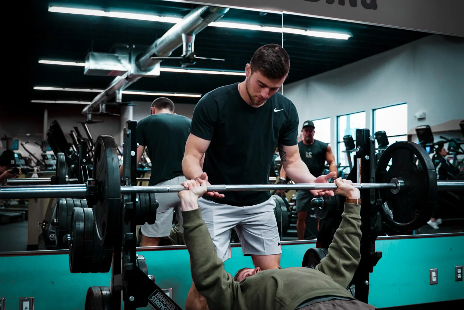 Devon coaching a client through a bench press